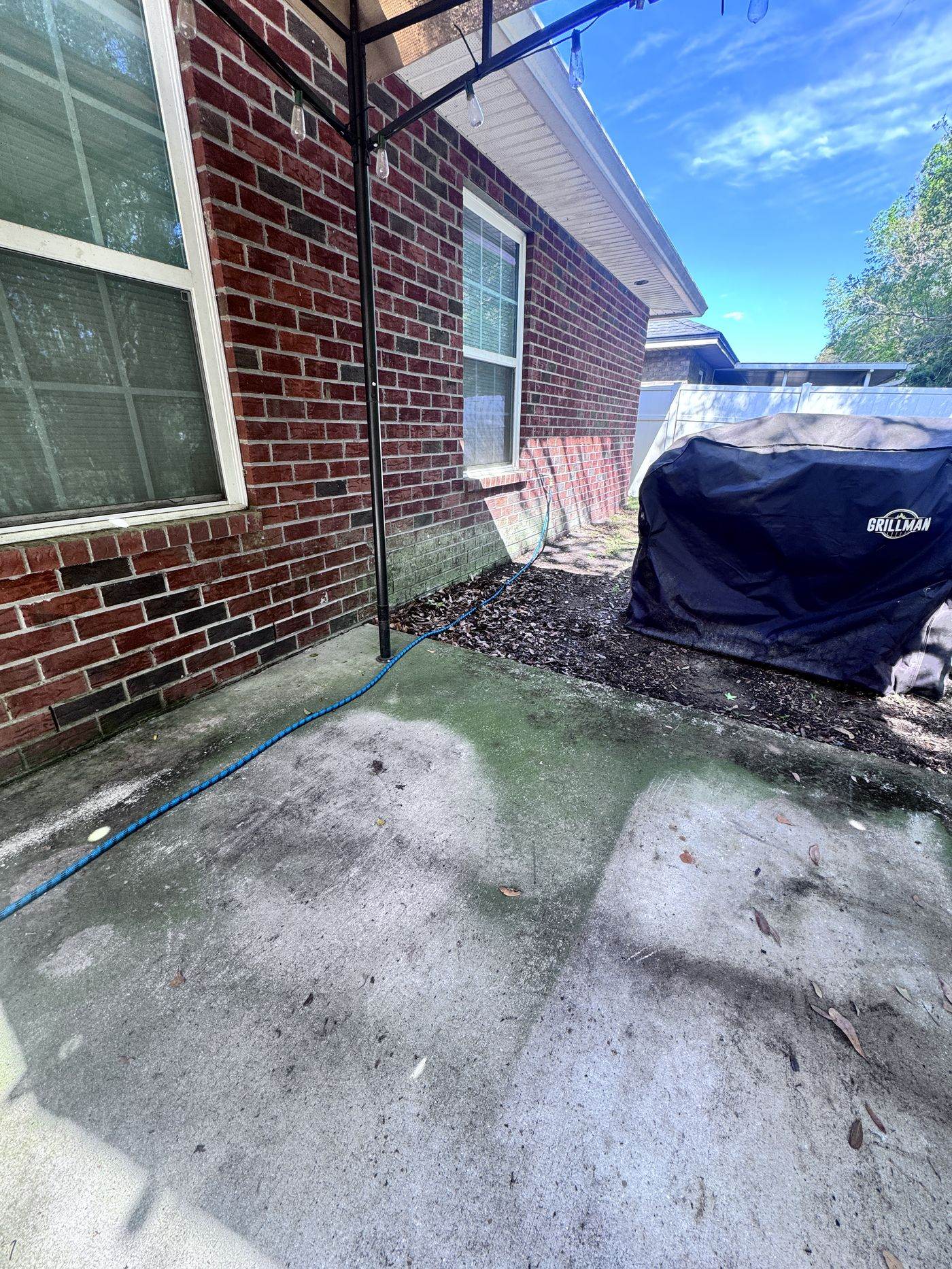 Patio concrete after pressure washing, clean and bright